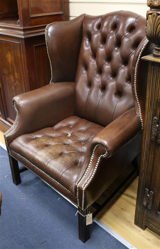 A leather button back wing armchair